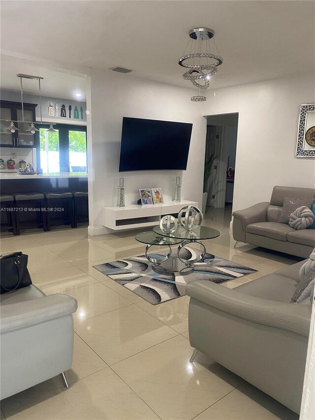 tiled living room featuring a notable chandelier