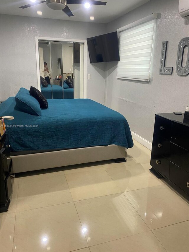 tiled bedroom with a closet, ceiling fan, and a wall mounted air conditioner