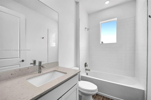 full bathroom with vanity, tiled shower / bath combo, and toilet