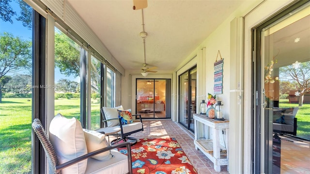 sunroom / solarium featuring ceiling fan