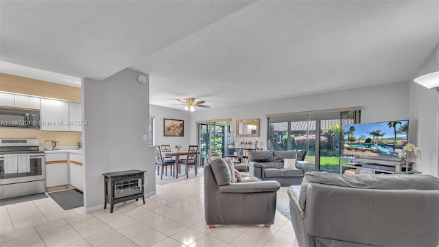 tiled living room with a textured ceiling and ceiling fan