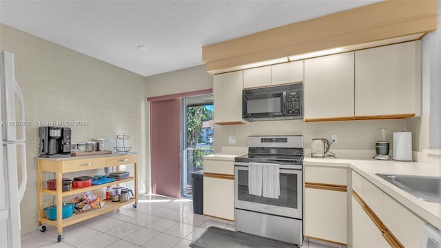 kitchen with decorative backsplash, white cabinets, a textured ceiling, stainless steel electric range oven, and light tile patterned flooring