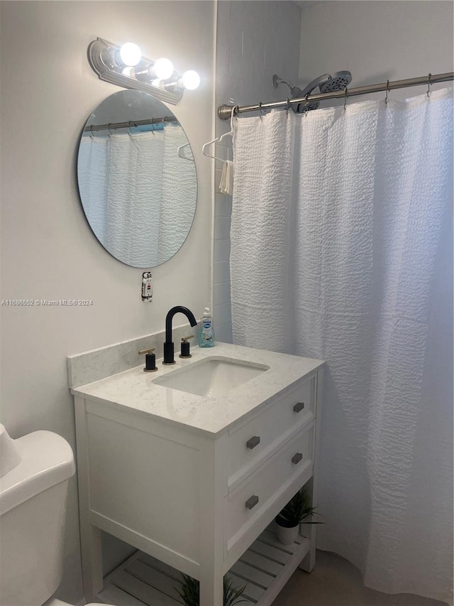 bathroom featuring toilet, vanity, and a shower with shower curtain