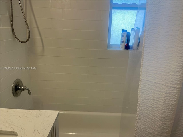 bathroom featuring tiled shower / bath and vanity