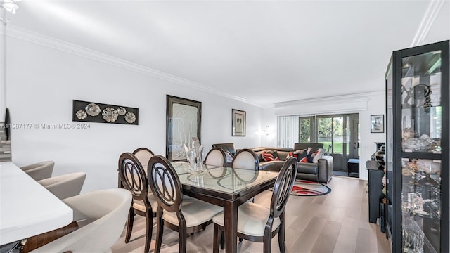 dining room with light hardwood / wood-style floors and crown molding