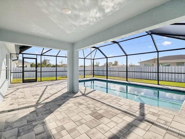 view of swimming pool with a patio area and a lanai