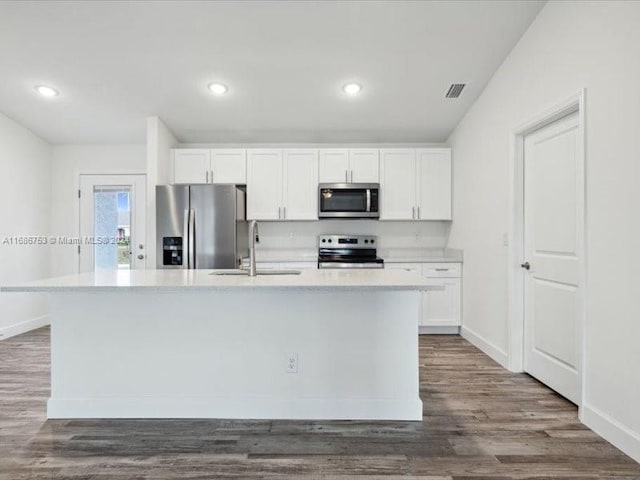 kitchen featuring dark wood-type flooring, a center island with sink, sink, white cabinetry, and appliances with stainless steel finishes