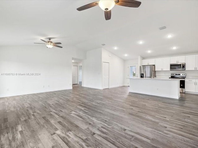 unfurnished living room with ceiling fan, hardwood / wood-style flooring, and lofted ceiling