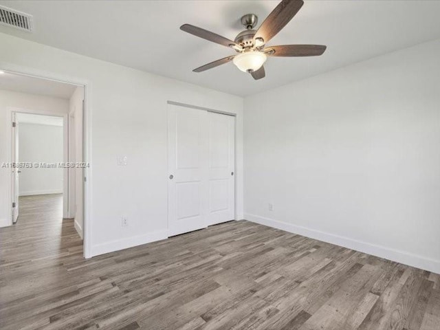 unfurnished bedroom featuring a closet, ceiling fan, and hardwood / wood-style flooring