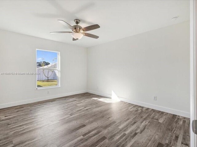 unfurnished room with dark wood-type flooring and ceiling fan