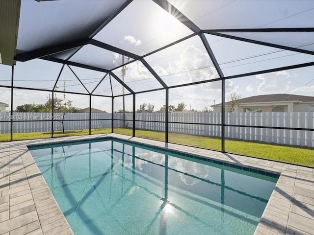 view of swimming pool with glass enclosure and a lawn