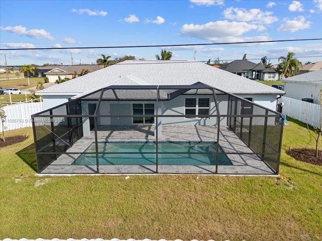 rear view of property with a patio, a fenced in pool, glass enclosure, and a lawn