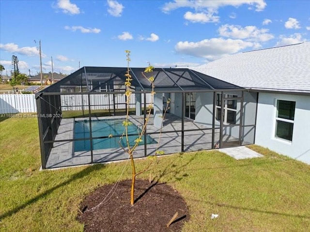 view of swimming pool featuring a patio, glass enclosure, and a lawn