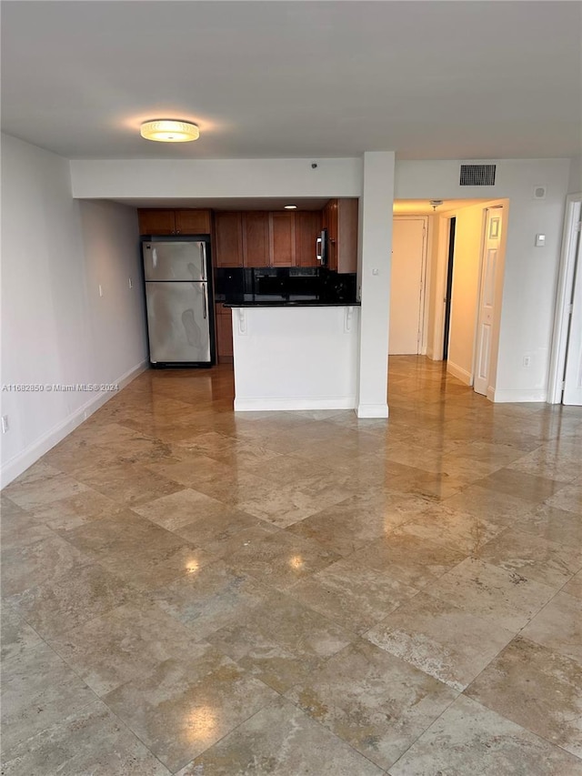 kitchen with stainless steel fridge and tasteful backsplash