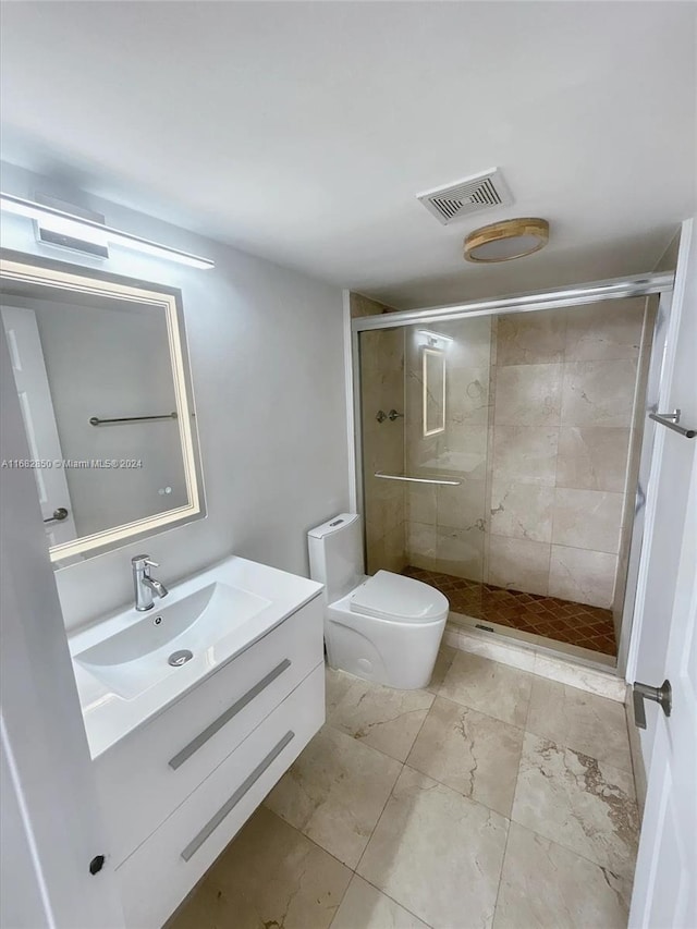 bathroom with a shower with door, vanity, and toilet