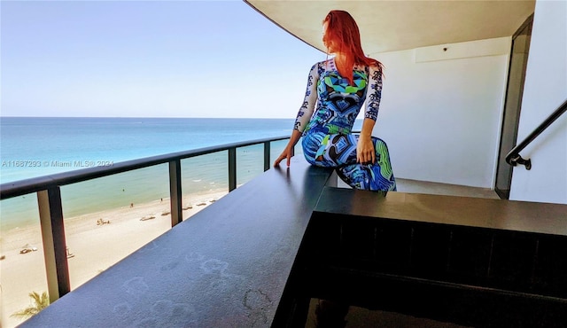 balcony featuring a water view and a beach view