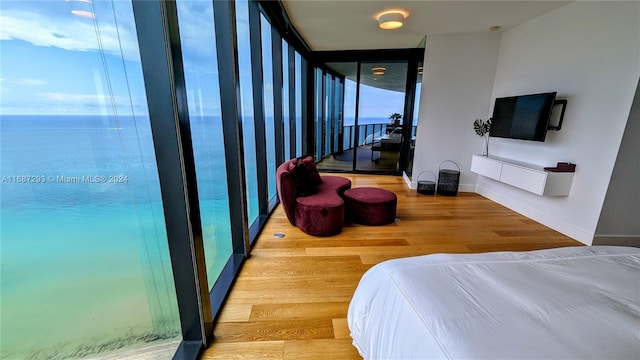 bedroom with a water view and wood-type flooring