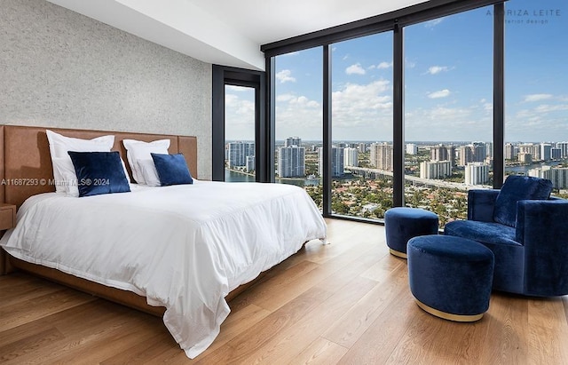 bedroom featuring expansive windows and wood-type flooring