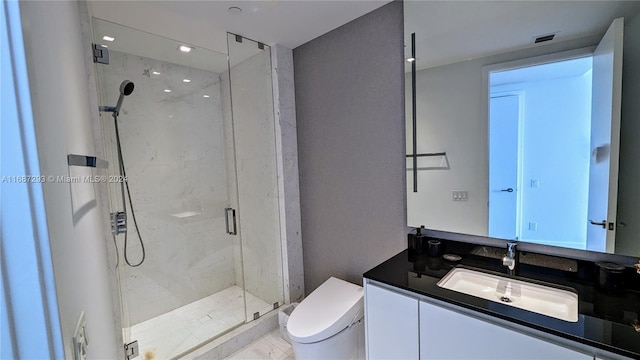 bathroom with vanity, toilet, and a shower with shower door