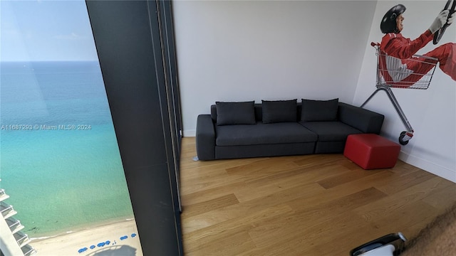 living room featuring light wood-type flooring and a water view