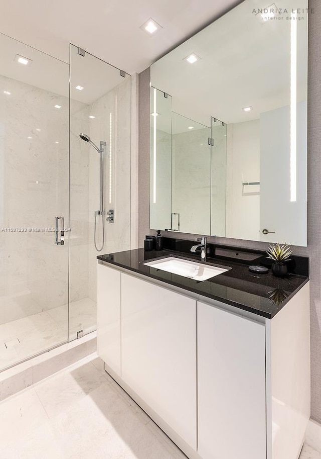 bathroom with vanity and a shower with door