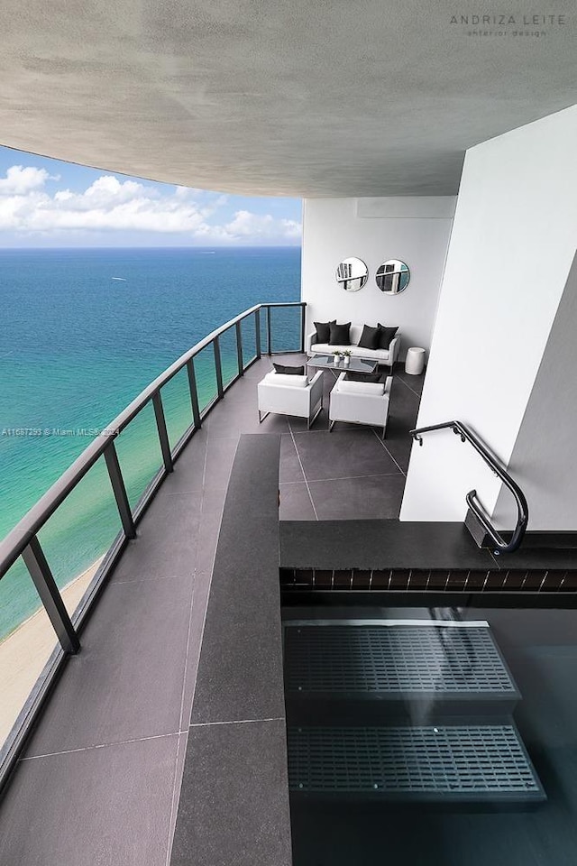 balcony with a water view and an outdoor hangout area