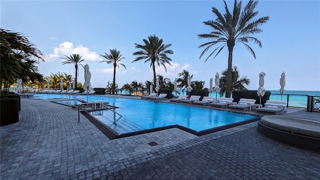 view of swimming pool with a patio and a water view