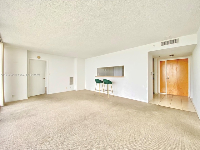 carpeted empty room with a textured ceiling