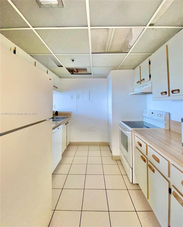 kitchen featuring sink, light tile patterned floors, white cabinetry, a paneled ceiling, and white appliances