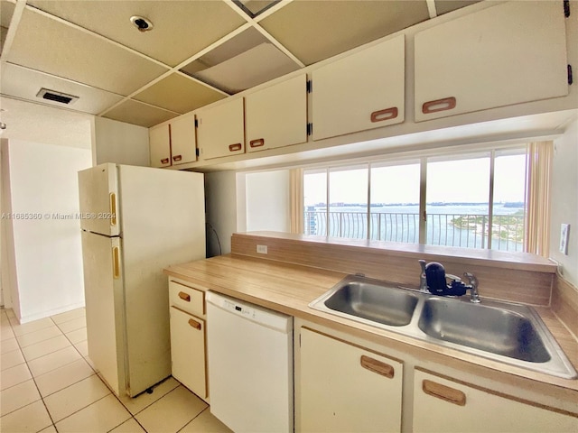 kitchen featuring sink, a water view, white appliances, and plenty of natural light