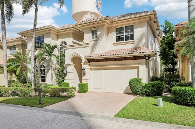 mediterranean / spanish-style home with a front yard and a garage