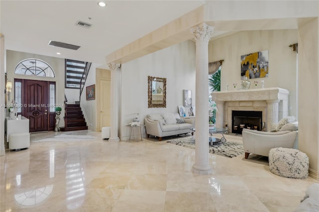 foyer entrance featuring a high end fireplace and decorative columns