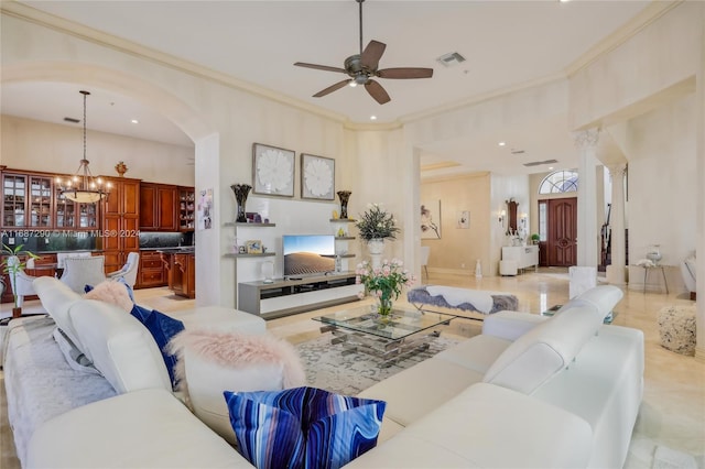 living room featuring ornamental molding, a high ceiling, light tile patterned flooring, and ceiling fan with notable chandelier