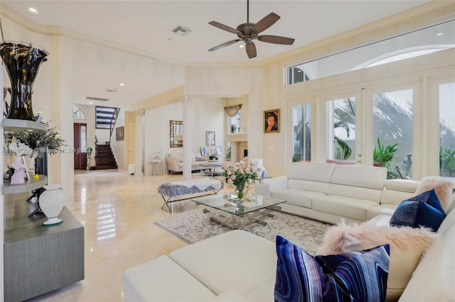 living room featuring ornamental molding, a high ceiling, and ceiling fan