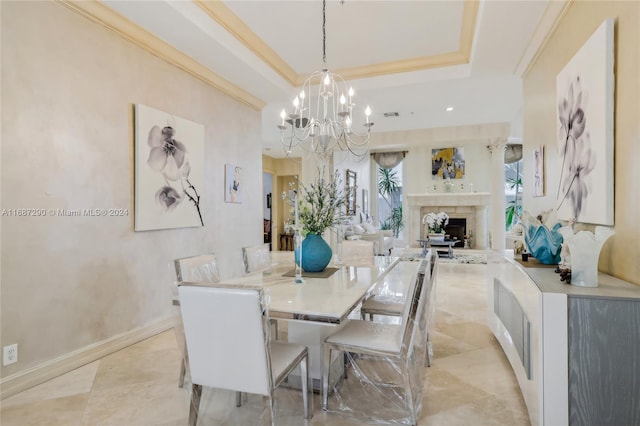 dining area with crown molding, a tray ceiling, and a chandelier