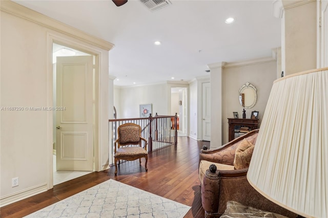 living area with crown molding and dark wood-type flooring