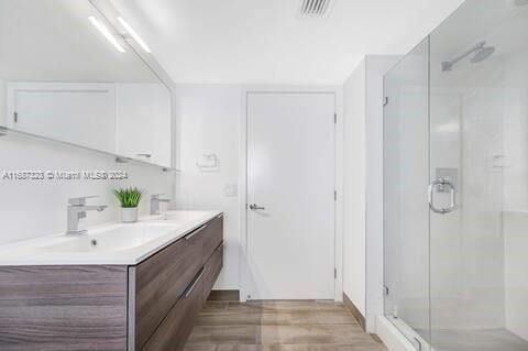 bathroom with vanity, wood-type flooring, and walk in shower