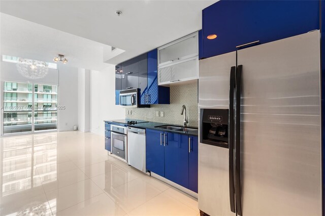 kitchen featuring tasteful backsplash, sink, appliances with stainless steel finishes, light tile patterned floors, and blue cabinets