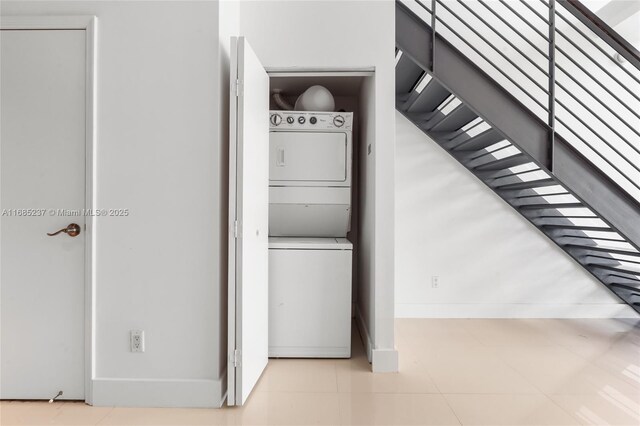 laundry area featuring tile patterned flooring and stacked washer and dryer