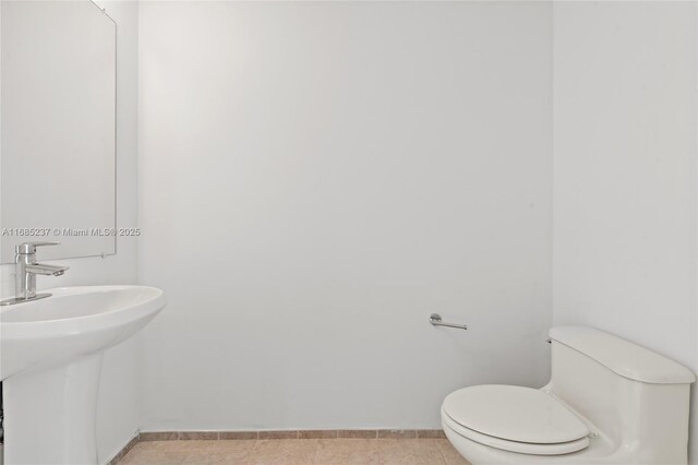 bathroom featuring sink, toilet, and tile patterned flooring