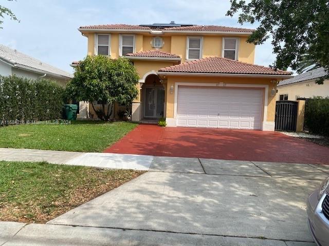 mediterranean / spanish house featuring a front lawn and a garage