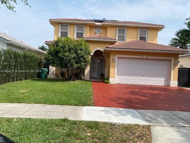 mediterranean / spanish-style house with a front lawn and a garage