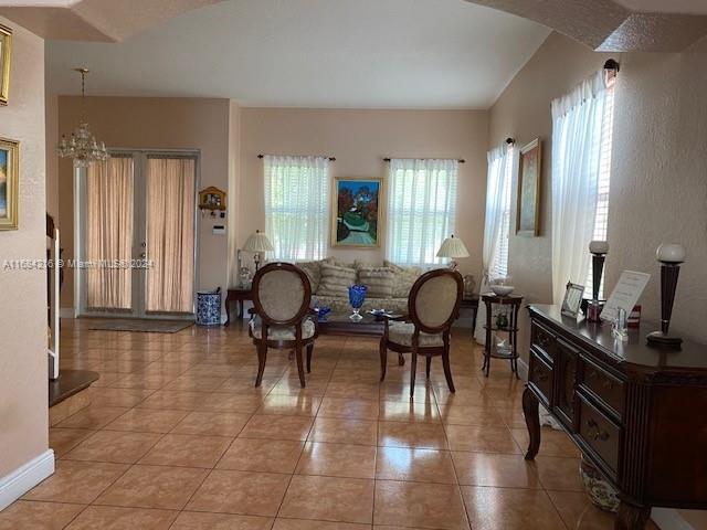 living area with light tile patterned flooring and an inviting chandelier