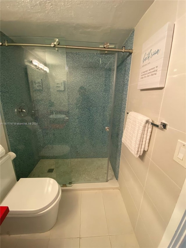 bathroom featuring tile patterned floors, toilet, and an enclosed shower