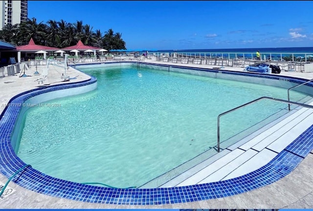 view of pool featuring a patio and a water view