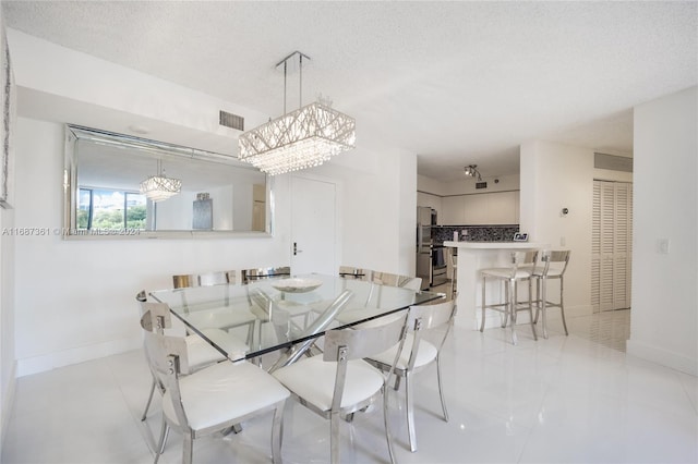 tiled dining space featuring a textured ceiling