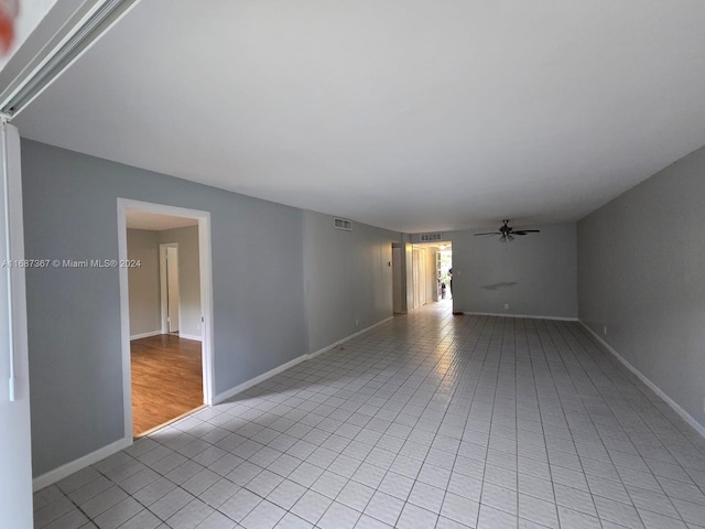 unfurnished room with light tile patterned floors and ceiling fan