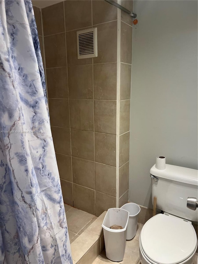 bathroom with toilet, a shower with curtain, and tile patterned flooring