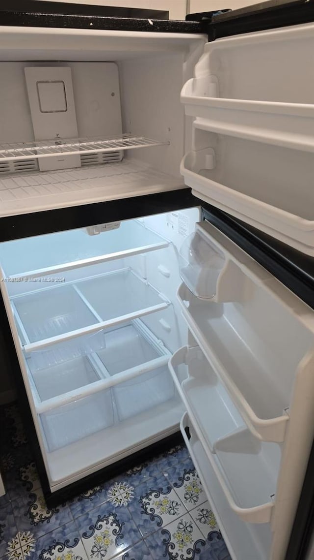 details featuring tile patterned floors and refrigerator