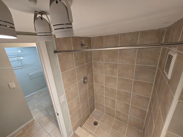 bathroom with a tile shower and tile patterned floors